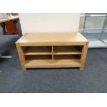A contemporary oak television stand fitted shelves beneath,