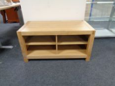 A contemporary oak television stand fitted shelves beneath,