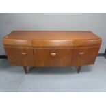 A mid 20th century teak bow fronted cocktail sideboard