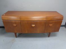 A mid 20th century teak bow fronted cocktail sideboard