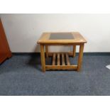 A teak coffee table with glass inset panel