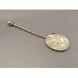 A silver embossed spoon depicting an African mother with child