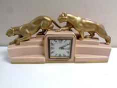 A French eight day Art Deco mantel clock surmounted by two gilt panthers