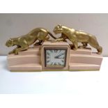 A French eight day Art Deco mantel clock surmounted by two gilt panthers