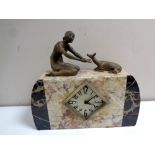 A marble Art Deco mantel clock surmounted by female figure with deer