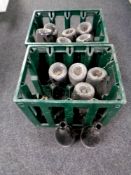 Two plastic brewery crates containing twelve vintage green glass wine bottles