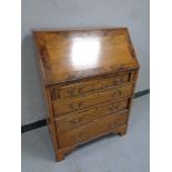 A 19th century oak writing bureau fitted four drawers beneath