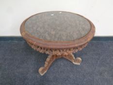 A heavily carved circular eastern hardwood pedestal occasional table