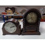 An Edwardian oak and pine mantel clock with silvered dial together with a further oak cased Art