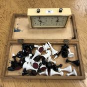 A chessboard and pieces together with a chess clock.