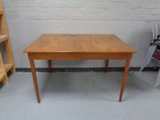 A mid 20th century extending dining table with leaf