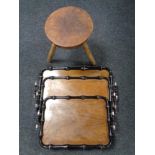 A graduated set of three ebonised twin handled serving trays together with a wooden tripod stool