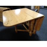 A contemporary pine drop leaf table