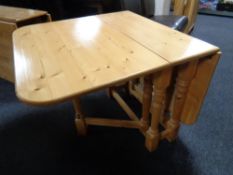 A contemporary pine drop leaf table