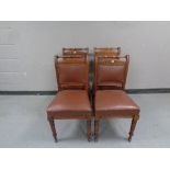 A set of four Edwardian mahogany dining chairs upholstered in a studded leather