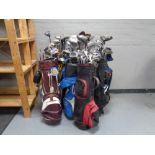 Ten golf bags containing a large quantity of child's and adult's drivers,