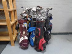 Ten golf bags containing a large quantity of child's and adult's drivers,