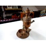 An antique copper tea urn on tray with kettle