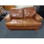 A two seater brown leather settee