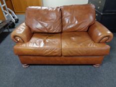 A two seater brown leather settee