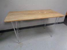 A 20th century wooden plank top table on metal hairpin legs,