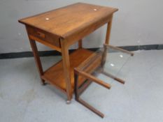 A 20th century teak two tier tea trolley on casters fitted a drawer,
