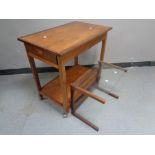 A 20th century teak two tier tea trolley on casters fitted a drawer,