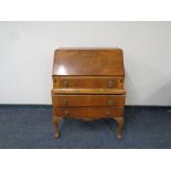 A walnut Queen Anne style bureau on claw and ball feet