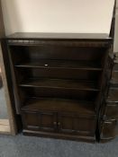 A set of Ercol open bookshelves fitted double door cupboard beneath in an antique finish,