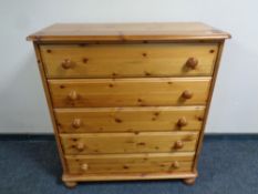 A contemporary pine five drawer chest,