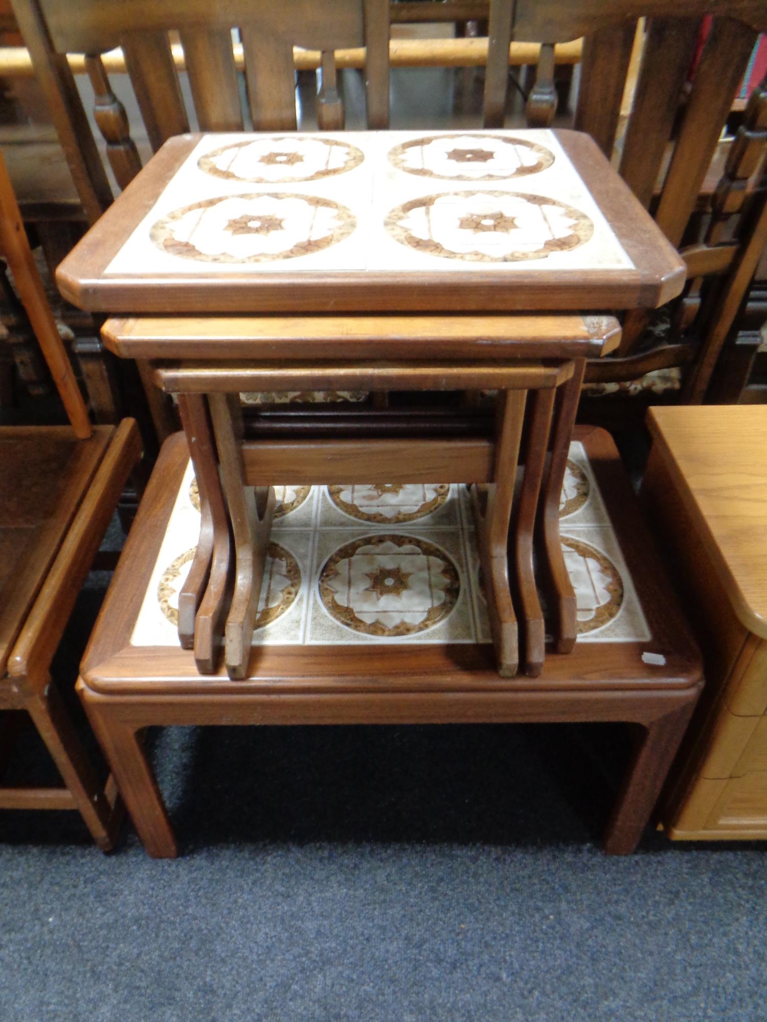 A mid 20th century teak G-Plan tile topped coffee table together with matching nest of three tables