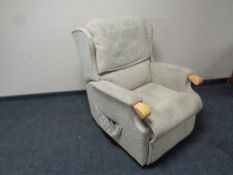 An electric reclining armchair upholstered in a beige fabric