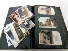 An antiquarian postcard album containing a large quantity of colour and monochrome postcards,