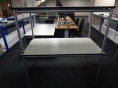 A pair of contemporary office table on tubular metal legs,