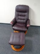 A Burgundy leather swivel relaxer armchair with stool