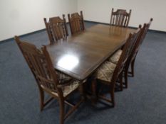 An old colonial style extending dining table together with a set of six matching high back chairs,