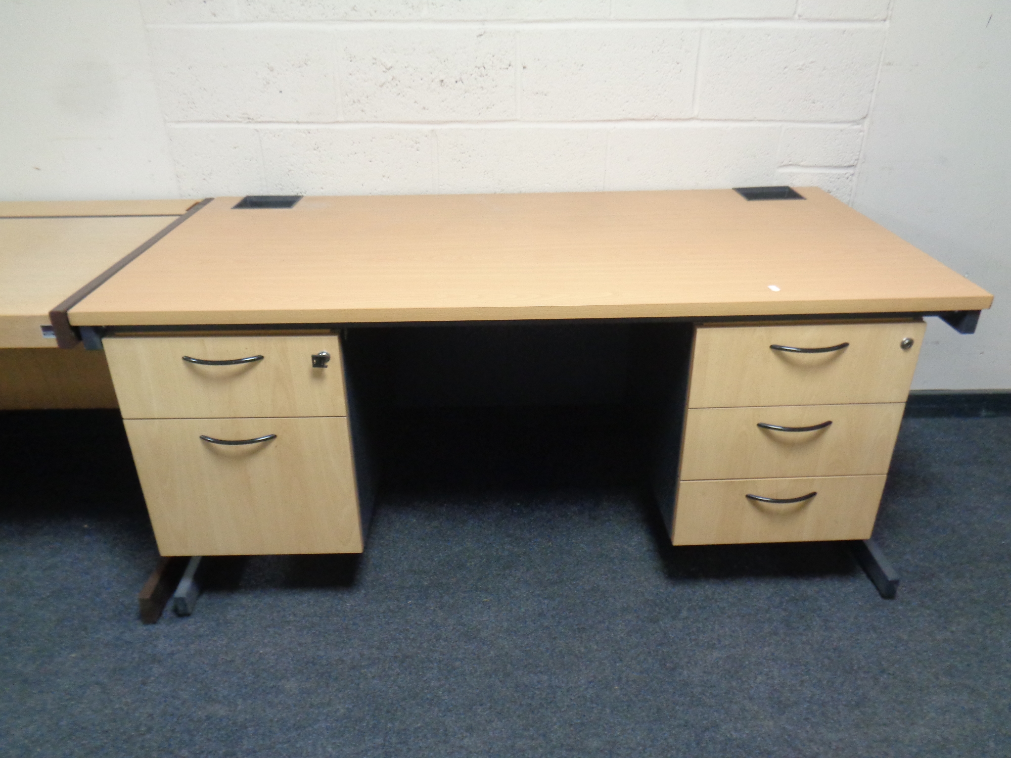 A contemporary twin pedestal office desk in a pine finish,