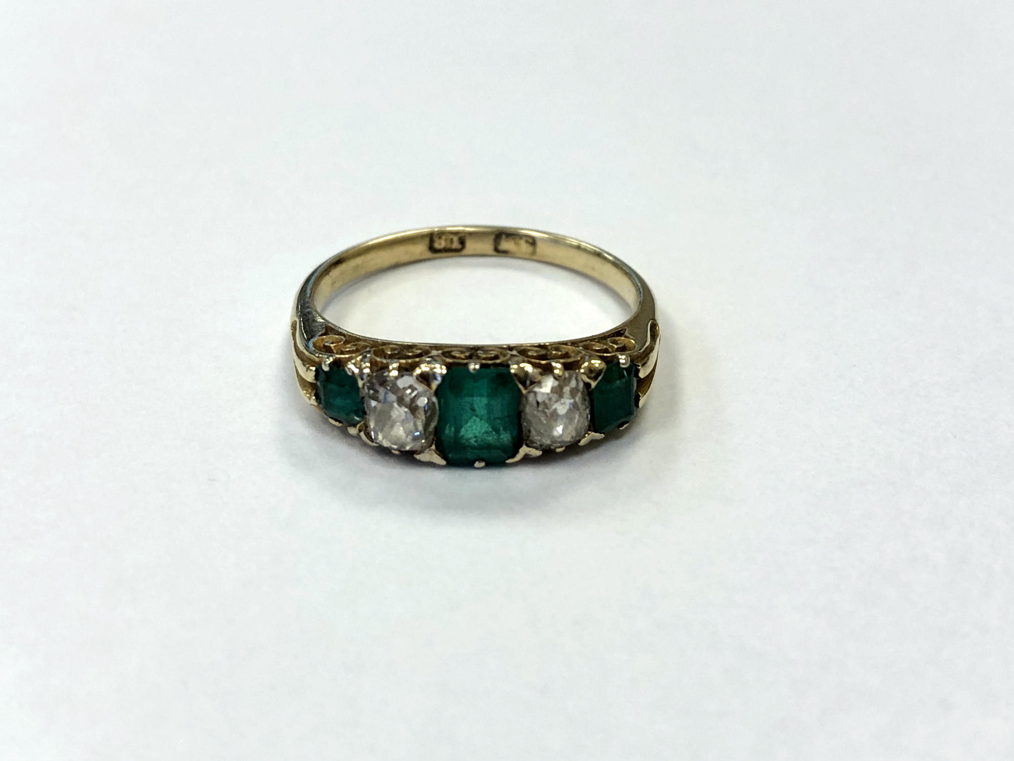 An 18ct gold emerald and two stone old cut diamond ring, size L/M, 2.7g.