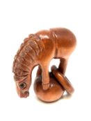 A Japanese carved hardwood netsuke : Horse with Hoop.