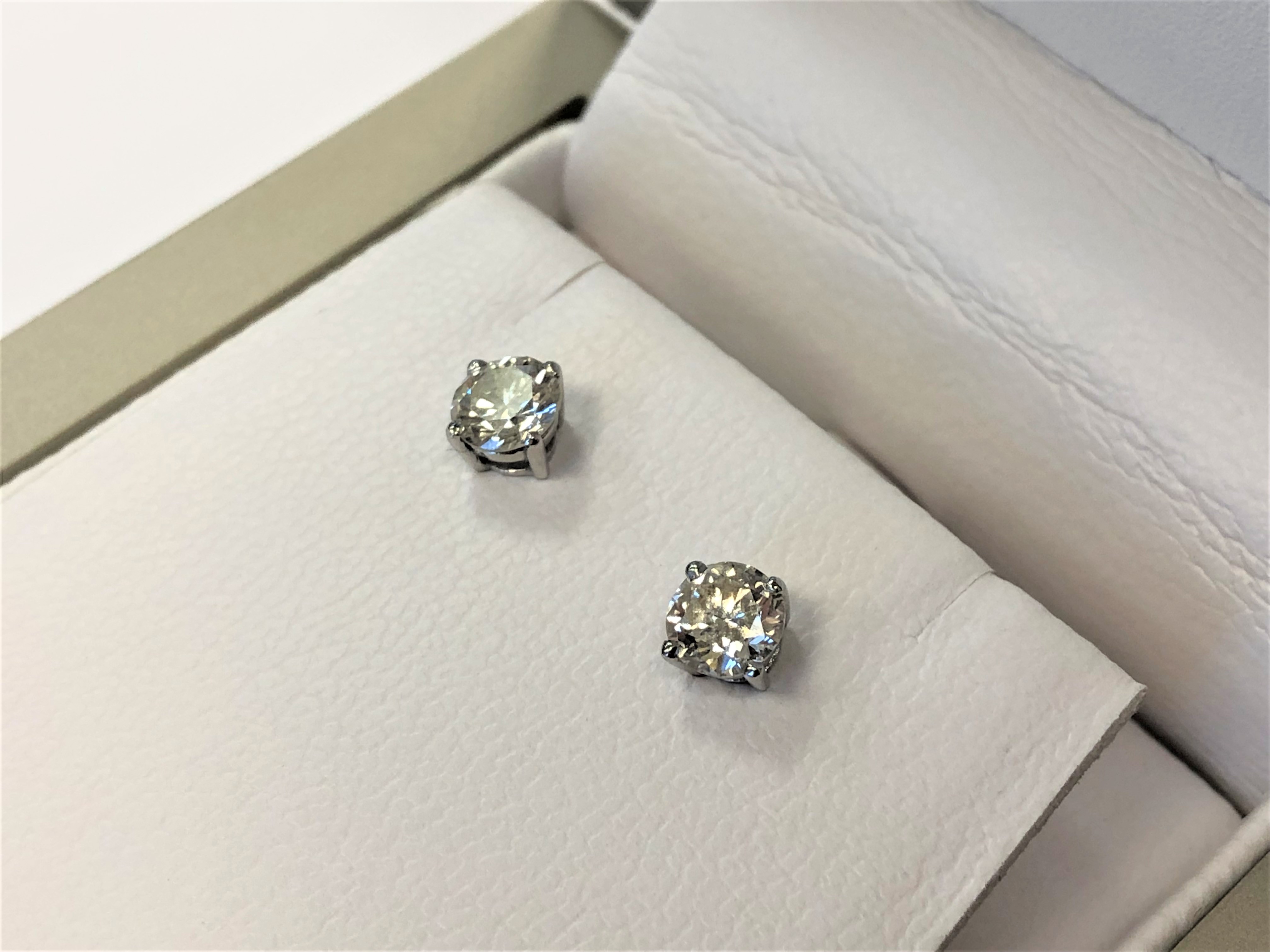 A pair of 18ct white gold diamond solitaire earrings,