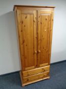 A contemporary pine double door wardrobe fitted two drawers beneath, height 183 cm,