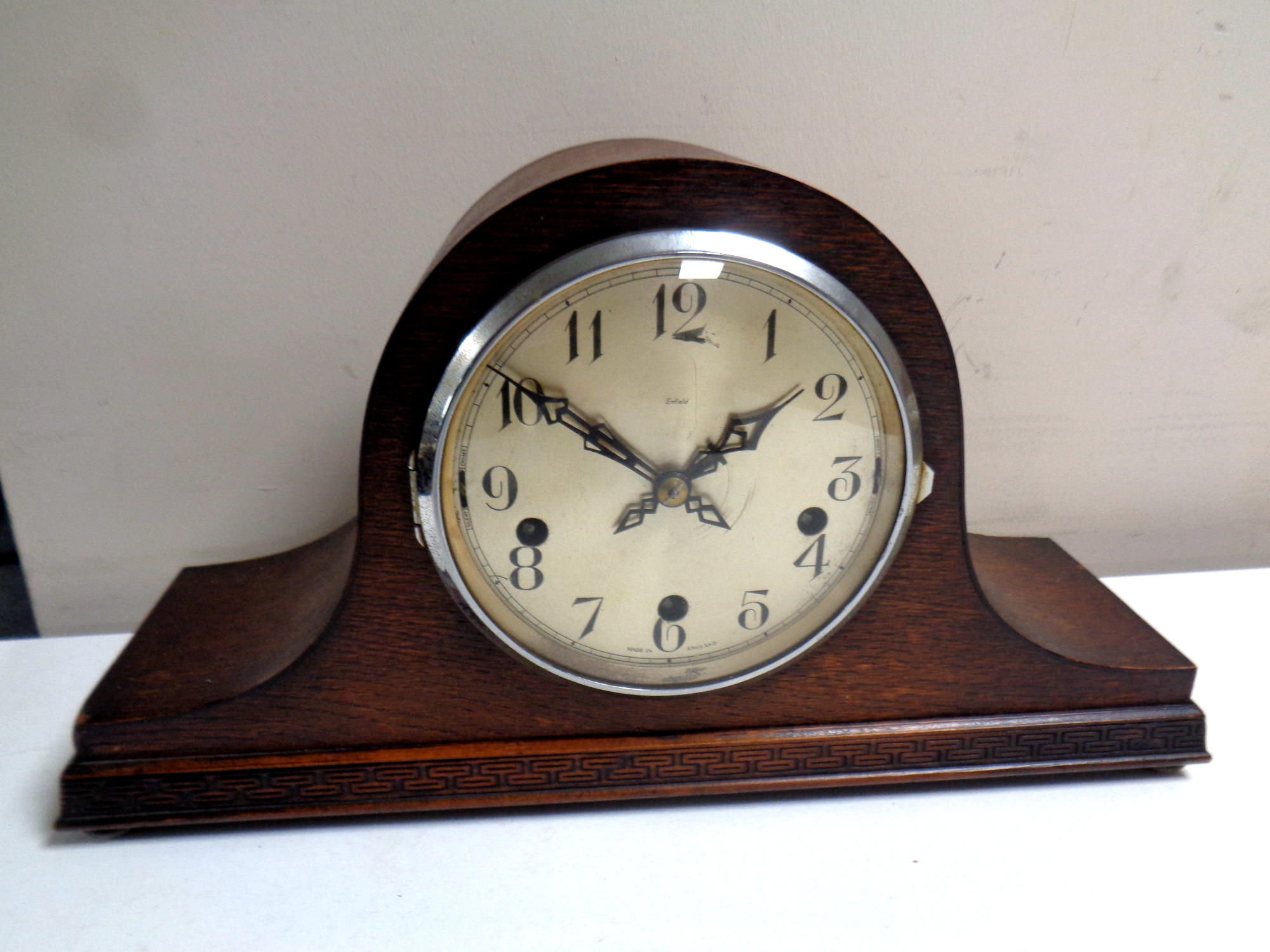 A 1930s oak cased Enfield mantel clock with silvered dial