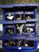 A tray containing nine pieces of Swarovski jewellery to include brooches, pendants, earrings etc,