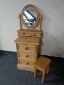 A stripped pine three drawer bedside chest together with dressing table mirror fitted two drawers