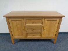 A contemporary oak sideboard fitted cupboards and drawers,