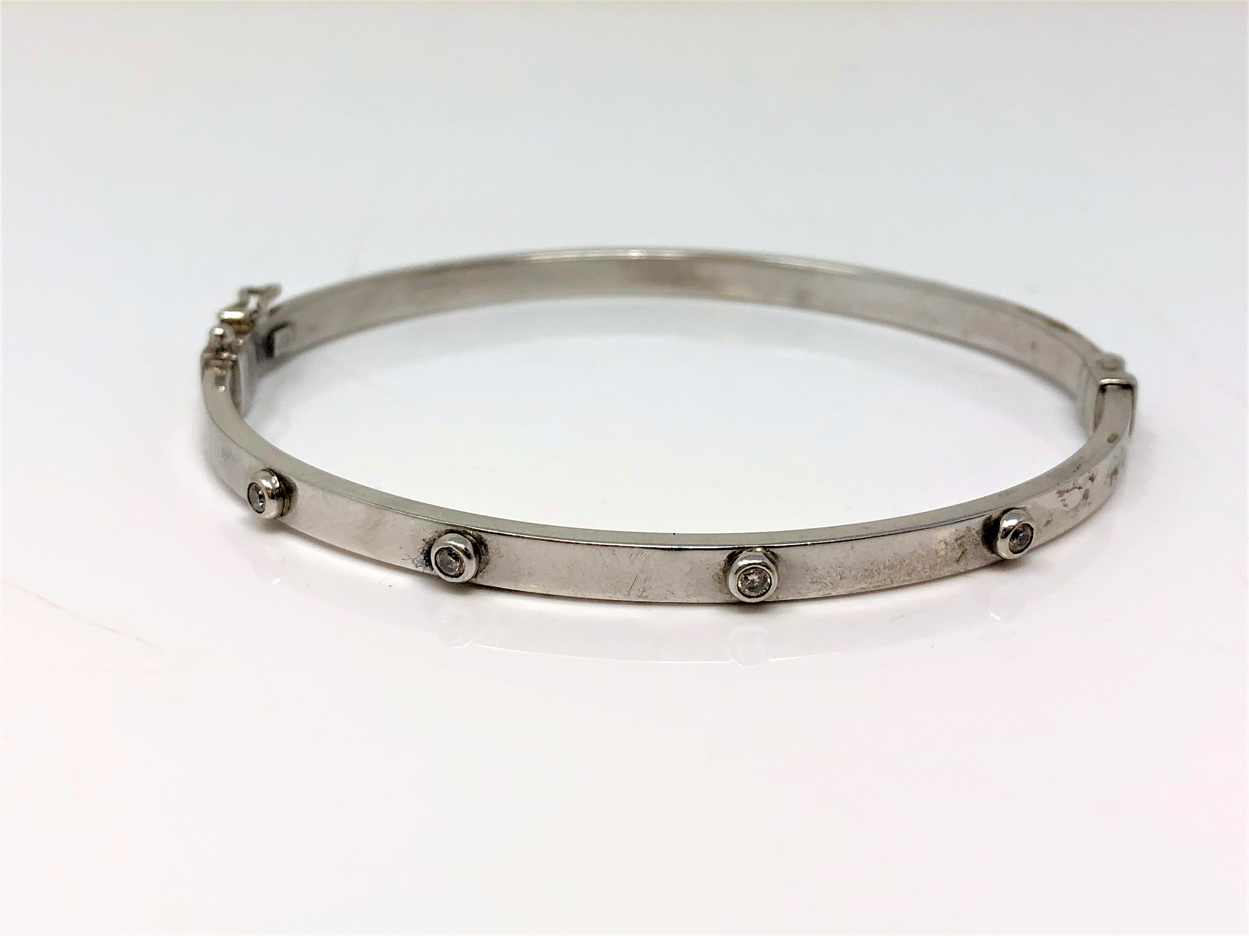 A 9ct white gold diamond set hinged bangle CONDITION REPORT: 5.