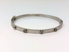 A 9ct white gold diamond set hinged bangle CONDITION REPORT: 5.