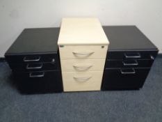 A pair of black three drawer under desk chests together with a further three drawer under desk