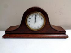 An Edwardian oak cased mantel clock on bun feet