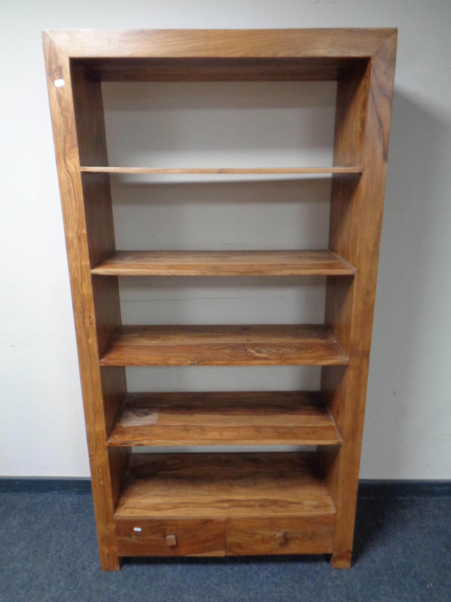 A set of sheesham wood open bookshelves fitted two drawers beneath, height 178.